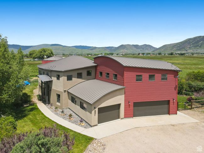 View of front of home featuring a standing seam roof, a mountain view, concrete driveway, metal roof, and an attached garage | Image 38