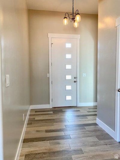 Entryway with wood-type flooring and a chandelier | Image 2