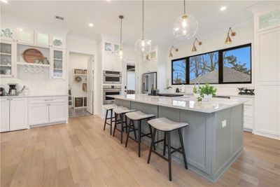 The gorgeous kitchen features a very large quartz-top island, built-in convection oven/microwave, and gas stove. | Image 3