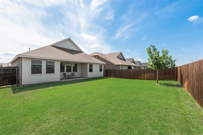 Rear view of property featuring a fenced backyard, a shingled roof, and a patio | Image 22