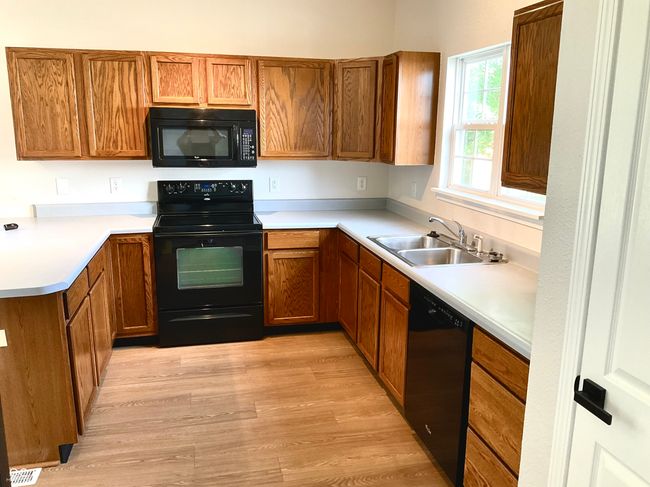 Light and bright kitchen with lot's of cabinet storage and prep/serving space. | Image 19