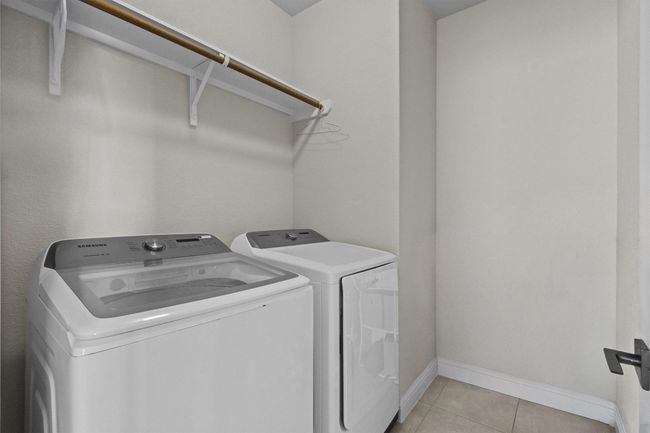 Laundry room featuring washer and clothes dryer and light tile patterned floors | Image 27