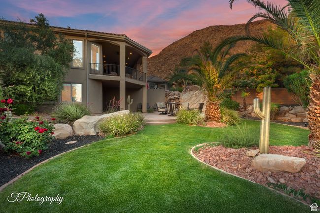 Rear view of property featuring a balcony, stucco siding, a yard, a patio area, and a mountain view | Image 49