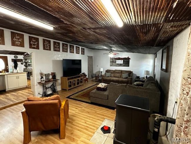Living room featuring light wood-type flooring and ceiling fan | Image 16