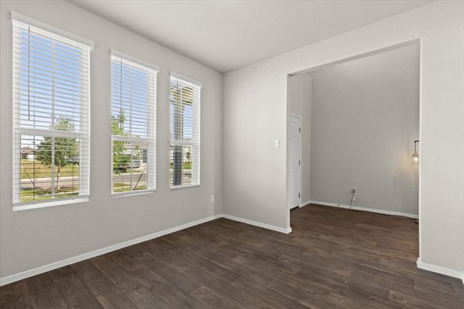 Unfurnished room with healthy amount of natural light, dark wood-style floors, and baseboards | Image 6