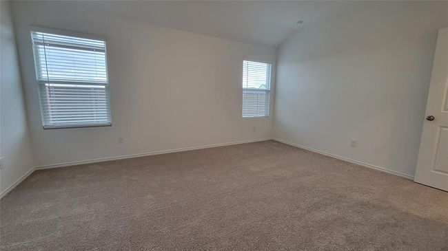 Carpeted spare room featuring vaulted ceiling and baseboards | Image 10