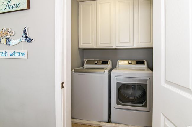 Laundry area featuring washing machine and dryer and cabinet space | Image 40