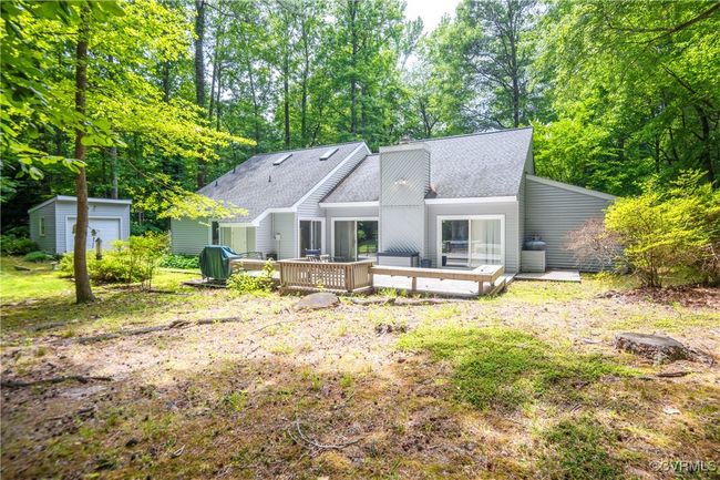 Rear view of property with a wooden deck, a shingled roof, an outdoor structure, and a chimney | Image 30