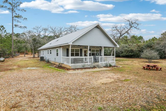 View of front of property featuring a front yard, central air condition unit, and a porch | Image 7