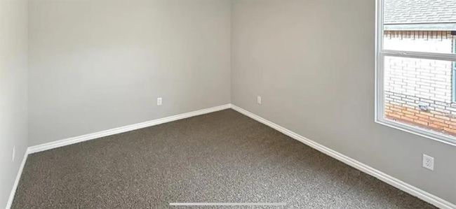 Unfurnished room featuring baseboards and dark colored carpet | Image 22