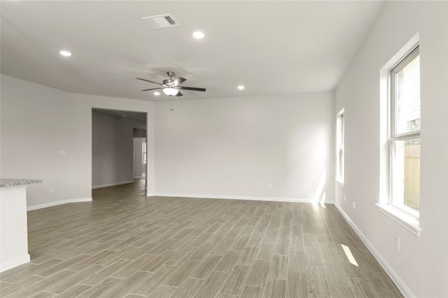 Empty room with ceiling fan, light wood-style flooring, and recessed lighting | Image 9