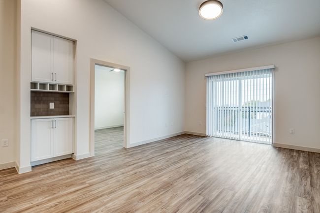Empty room featuring vaulted ceiling, light wood-style floors, visible vents, and baseboards | Image 4