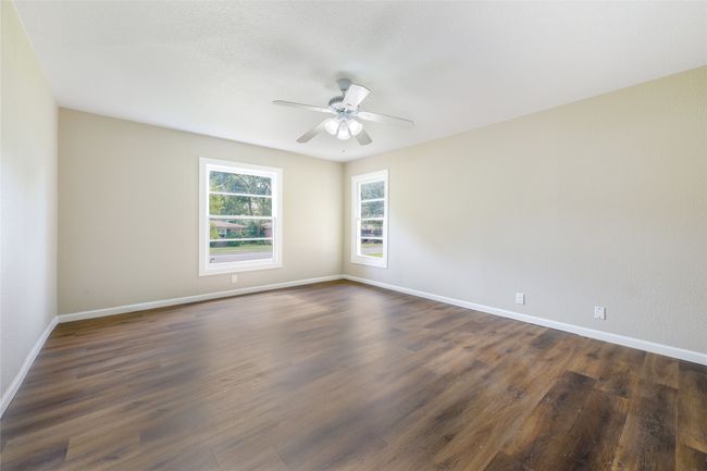 Unfurnished room featuring ceiling fan and dark wood-style flooring | Image 25