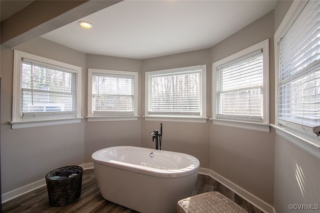 Full bathroom with a wealth of natural light, wood finished floors, baseboards, and a freestanding tub | Image 29