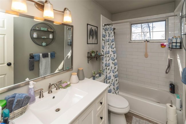 Bathroom with toilet, vanity, and shower / tub combo with curtain | Image 17