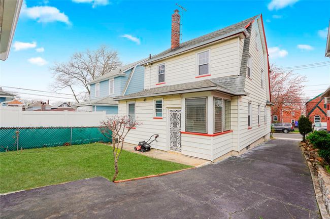 Rear view of house featuring roof with shingles, a chimney, fence, and a lawn | Image 29