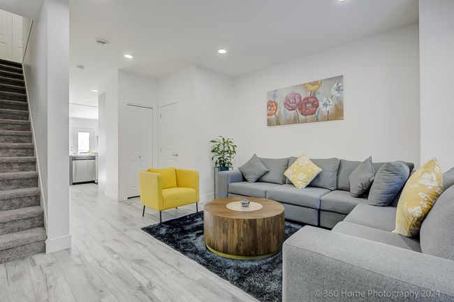 Living room with stairs, light wood finished floors, and recessed lighting | Image 17