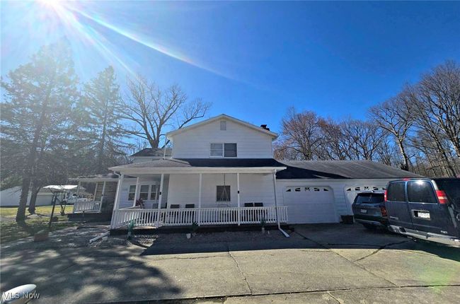 View of front of property featuring a porch, an attached garage, and concrete driveway | Image 5
