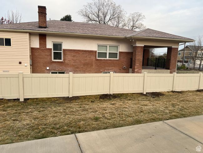 Rear view of property featuring a lawn, a chimney, fence, and brick siding | Image 28