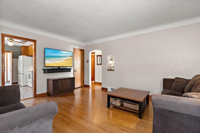 The kitchen and hallway leading to the main floor bedrooms and bathroom are accessible off of the living room. Notice the alcove shelf to the right of the hallway doorway for extra charm. | Image 9