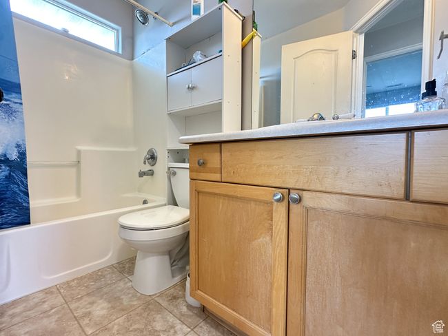 Full bathroom with tile floors, vanity, toilet, and bathtub / shower combination | Image 13