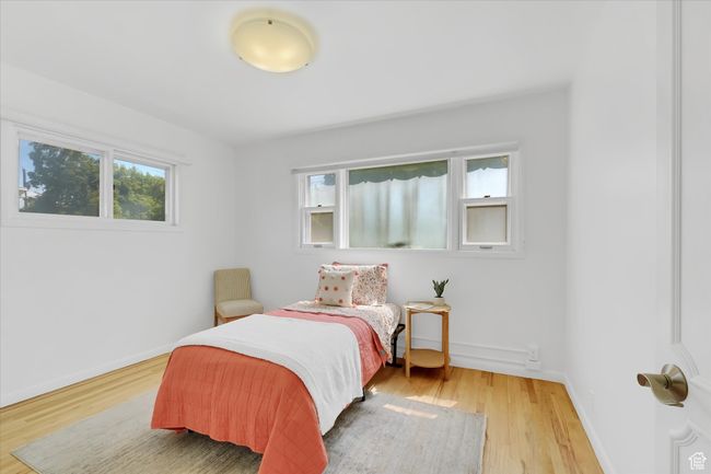 Bedroom with light wood-type flooring and baseboards | Image 13
