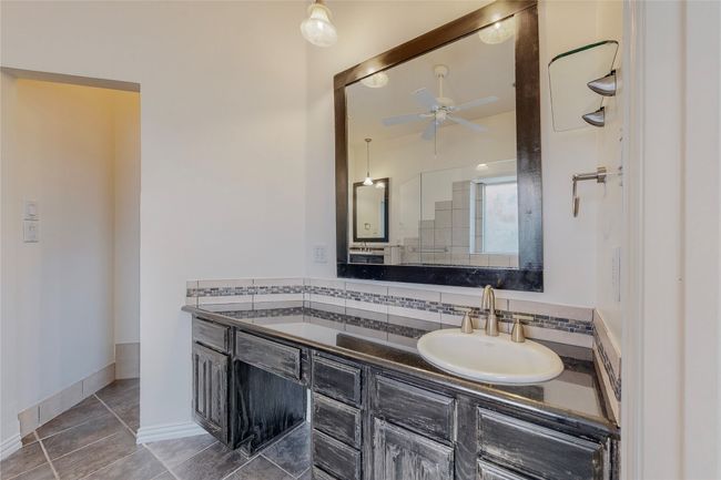 Full bath featuring ceiling fan, vanity, tasteful backsplash, and tile patterned flooring | Image 14