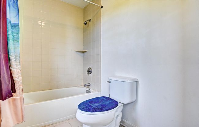 Bathroom with toilet, shower / bathtub combination with curtain, tile flooring | Image 25