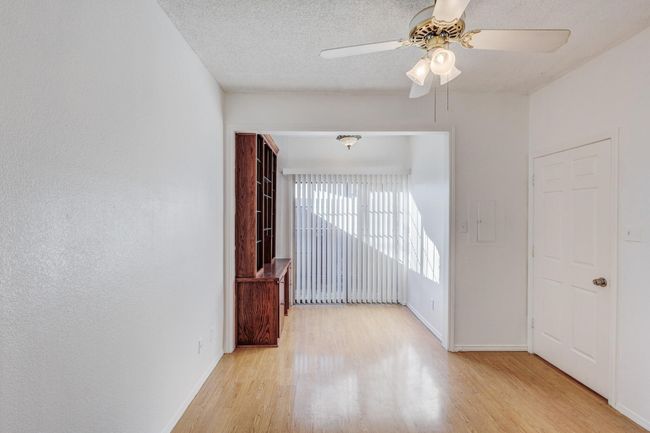 Spare room with light wood-type flooring, ceiling fan, baseboards, and a textured ceiling | Image 11