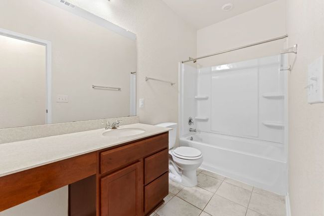 Guest bathroom with vanity, shower / bathtub combination, and tile patterned floors | Image 22