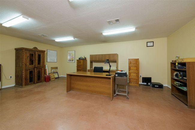 Office area featuring baseboards, a textured ceiling, and visible vents | Image 8