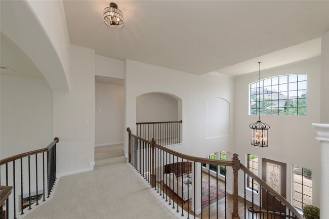 Hall with an upstairs landing, a chandelier, and carpet flooring | Image 25