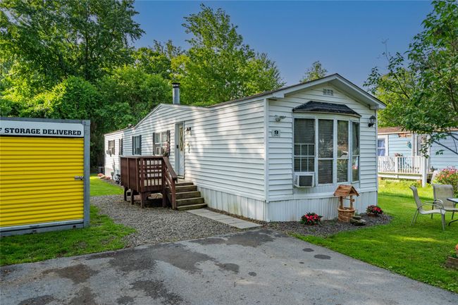 View of front facade with a wooden deck and a front yard | Image 17