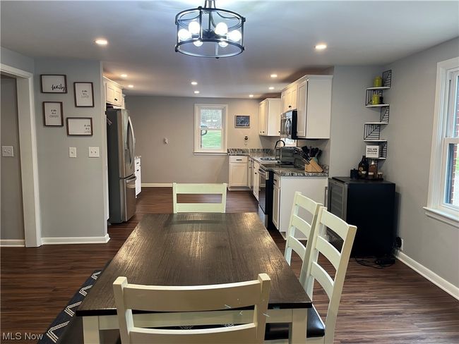 Kitchen featuring white cabinets, an inviting chandelier, stainless steel appliances, and dark hardwood / wood-style floors | Image 10