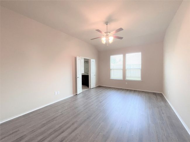 Unfurnished room featuring ceiling fan, dark wood-style flooring, and lofted ceiling | Image 9