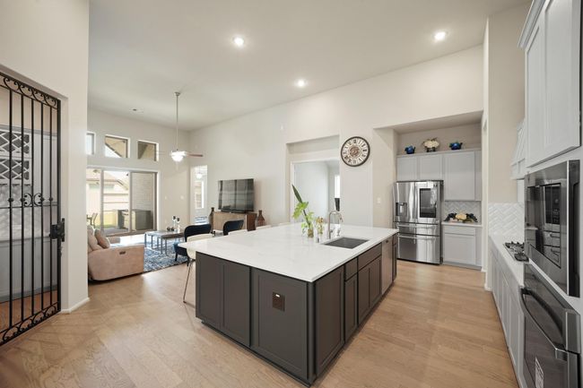 The kitchen, an integral part of thishome's open-concept design. The entertainers dream. Love how the wine cellar is right next door to the kitchen and the dining space. seamlessly flows off the living room, creating a harmonious andconnected living space. | Image 6