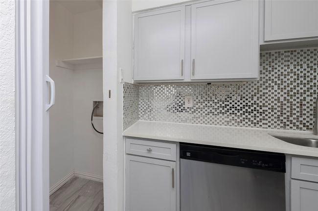 Kitchen featuring tasteful backsplash, stainless steel dishwasher, light countertops, and gray cabinetry | Image 8