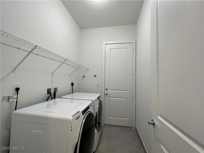 Laundry area featuring a textured ceiling and washing machine and dryer | Image 30