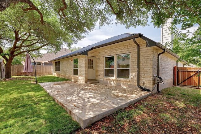 Rear view of property featuring a chimney, a patio area, fence, and a lawn | Image 33