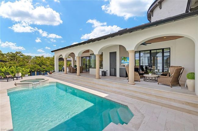 View of pool with a patio, an outdoor living space, and a pool with connected hot tub | Image 41