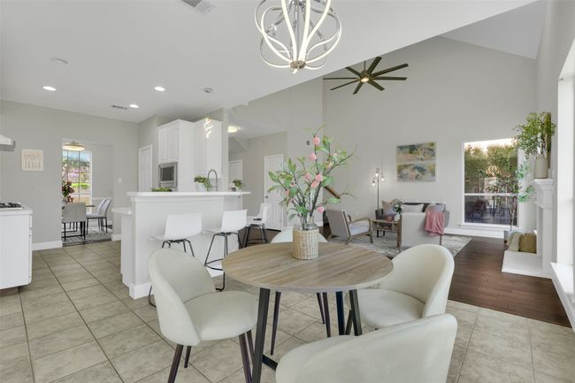Dining room with light tile patterned flooring, a chandelier, a ceiling fan, recessed lighting, and high vaulted ceiling | Image 11