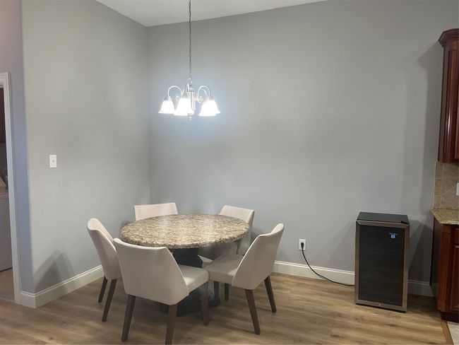Dining space featuring light wood finished floors and a chandelier | Image 9