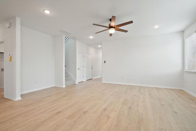 Spare room with ceiling fan, recessed lighting, light wood finished floors, and stairway | Image 11