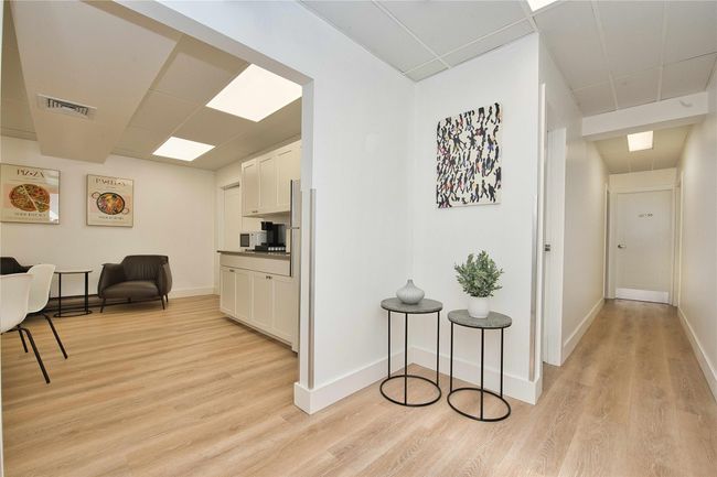 Hall featuring light wood-style floors, baseboards, and a drop ceiling | Image 5