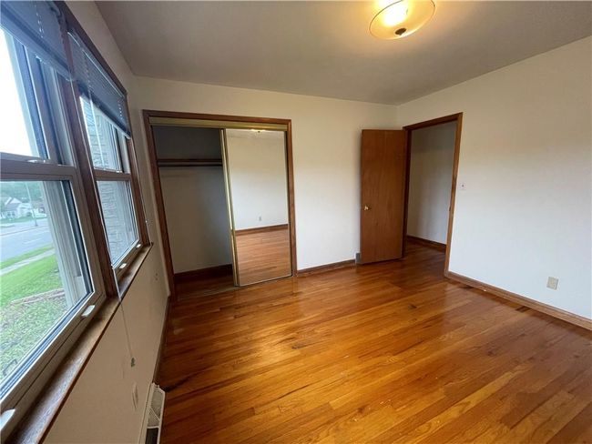 Unfurnished bedroom with light wood finished floors, a closet, visible vents, and baseboards | Image 14