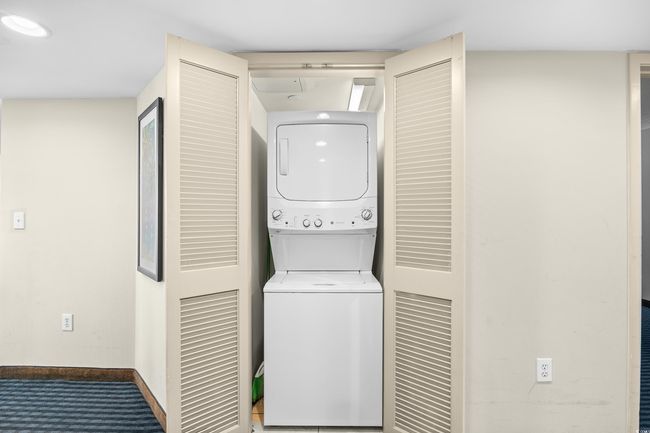 Laundry area with laundry area, carpet flooring, stacked washer and dryer, and baseboards | Image 25