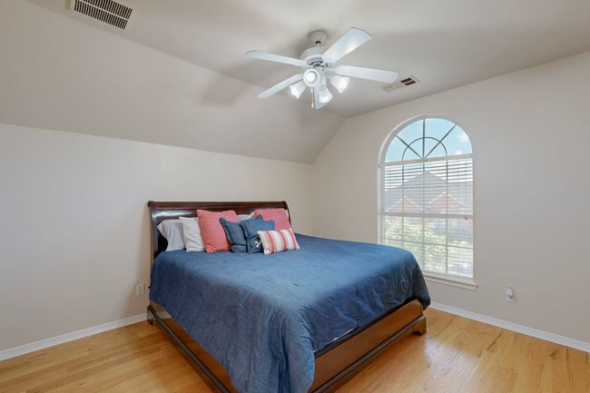 Bedroom with light wood-style flooring, visible vents, and multiple windows | Image 28