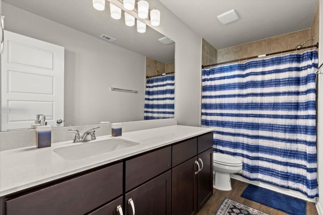 Full bath featuring vanity, wood finished floors, toilet, and curtained shower | Image 26