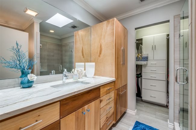 Bathroom with crown molding, vanity, a skylight, and a shower with shower door | Image 21