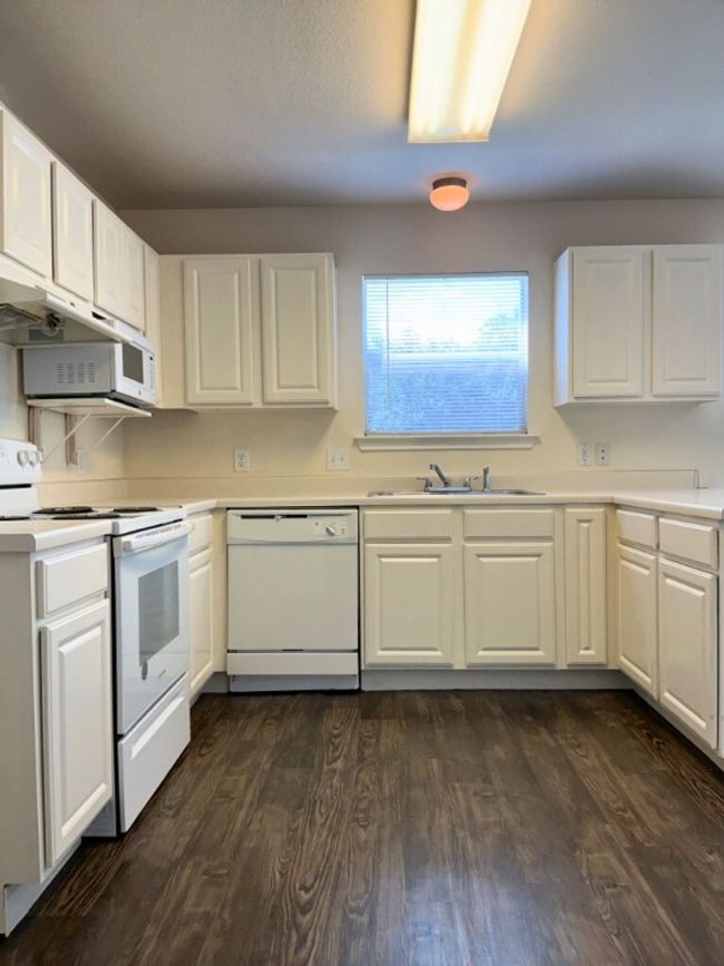 Kitchen with white appliances, white cabinets, and light countertops | Image 5